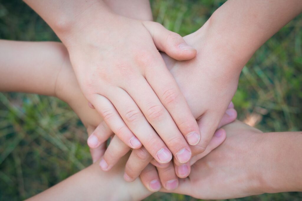 Close-up of diverse hands clasped together symbolizing unity and teamwork.